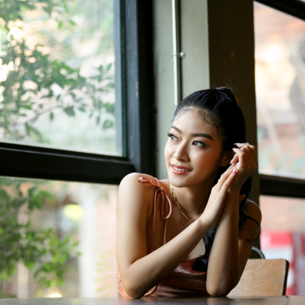 A woman sitting next to a window