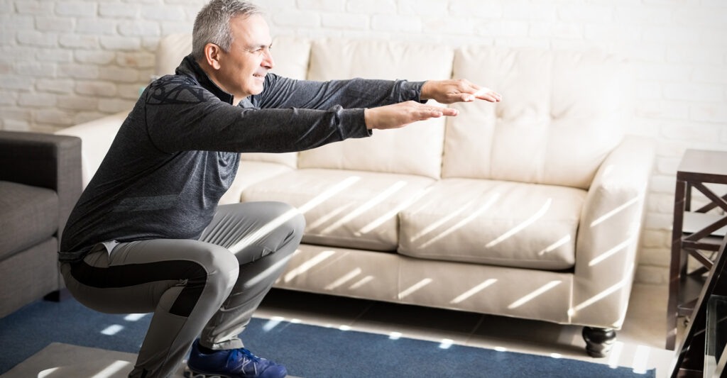 Man doing squats in his living room