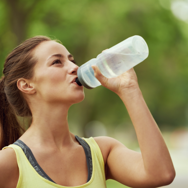A woman drinking water after a run