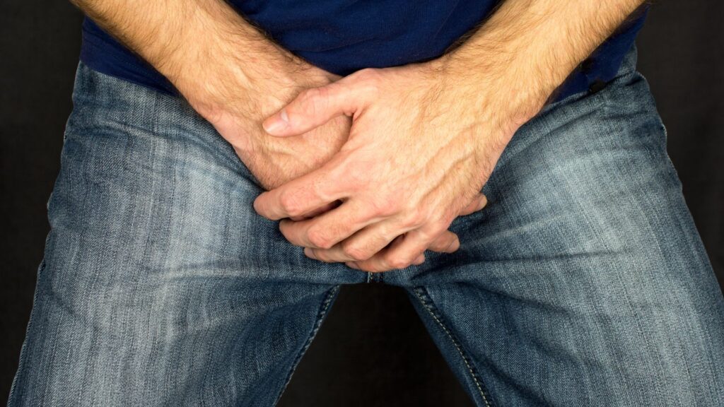 Man with hands over his crotch