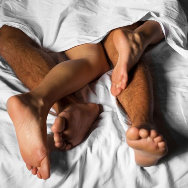 Couple's feet poking out from the sheets