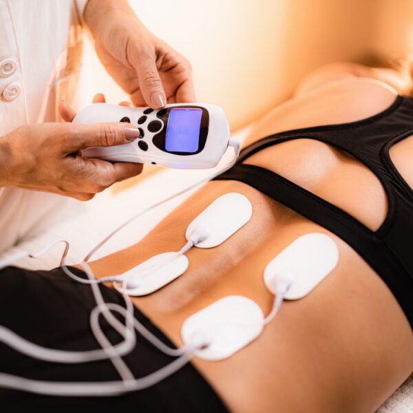 close up of a TENS unit for electro stim therapy on someone's lower back