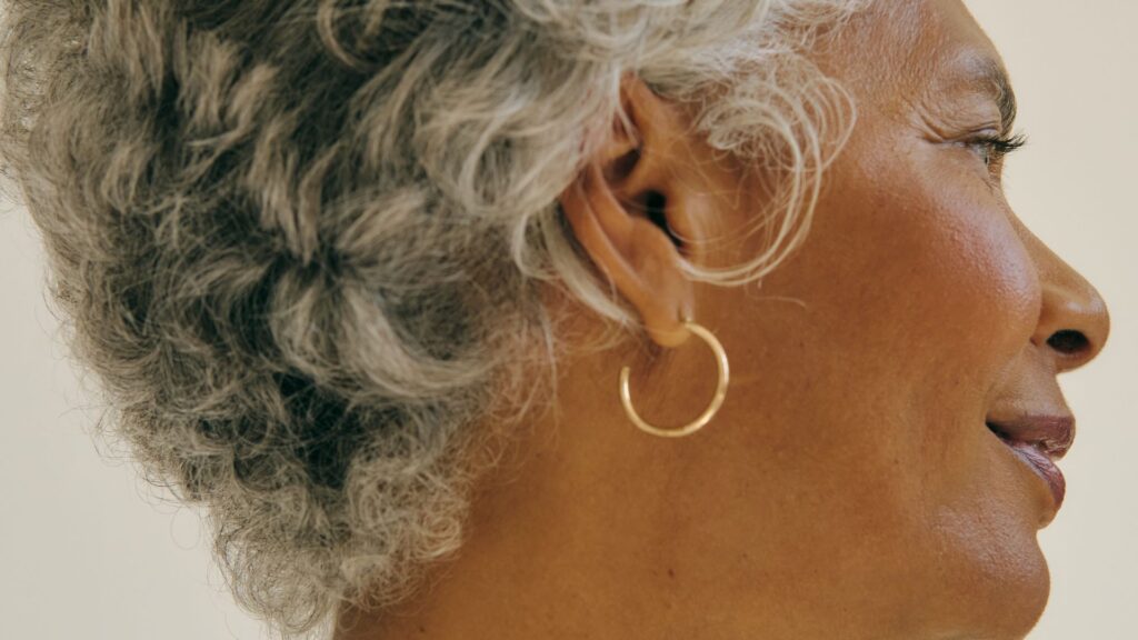 woman's wearing gold hoop earrings facial profile
