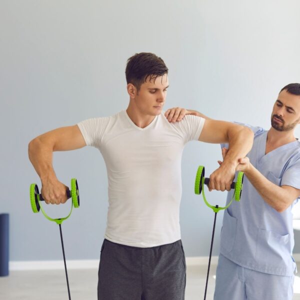 physical therapist helping man perform a weighted exercise