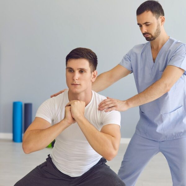 physical therapist helping man squat