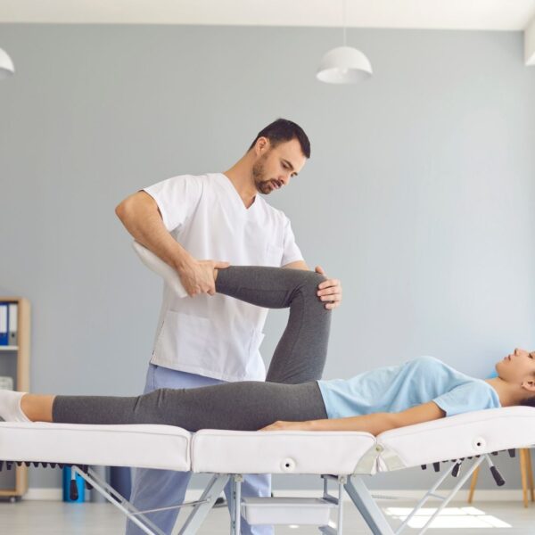 physical therapist helping woman stretch working on range of motion